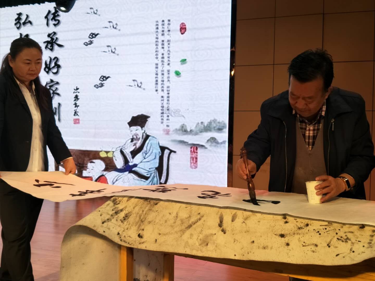 社区书法爱好者安华中老人写书法,"少年强点亮中国梦"寄语青少年.