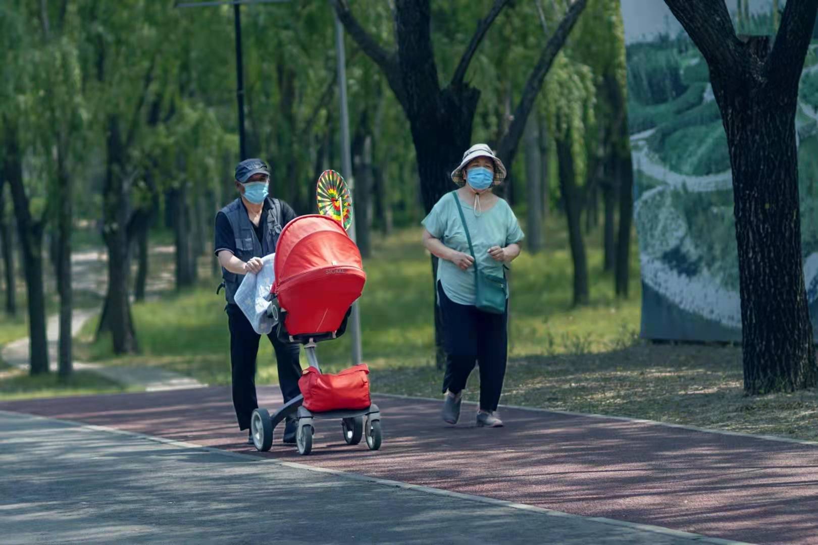 迎面看到三三兩兩的晨跑者跑在塑膠道上,有一對推著兒童車的老年人也