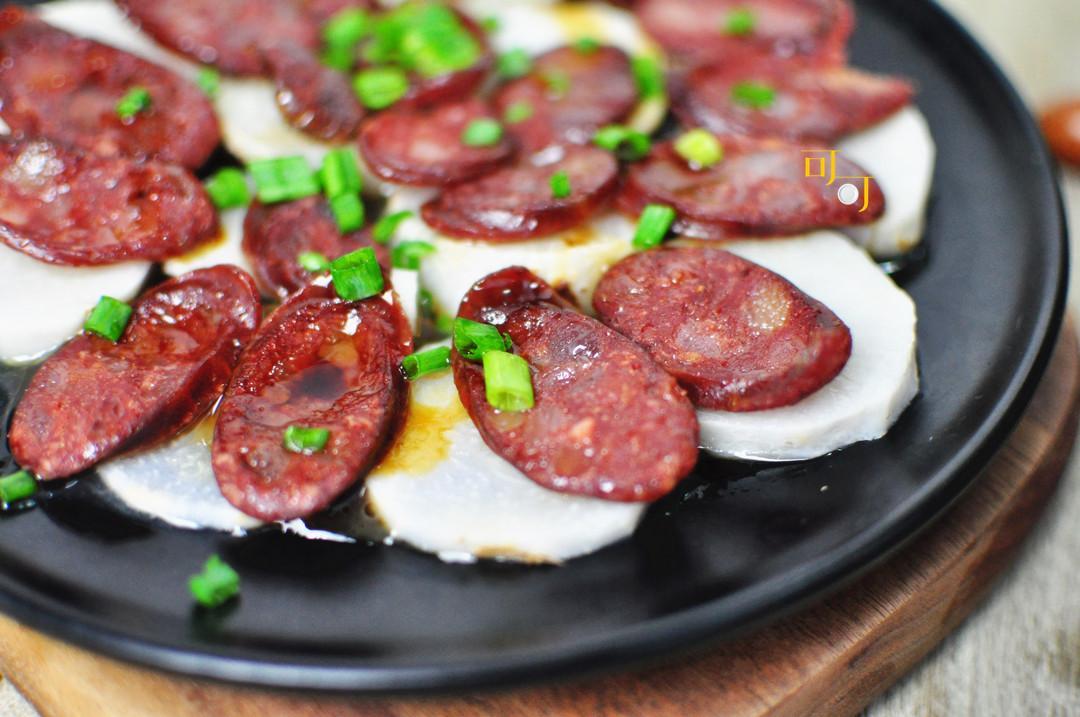 芋头去皮切5毫升厚片,葱切葱粒取一盘子,排好芋头片和腊肠上锅蒸20